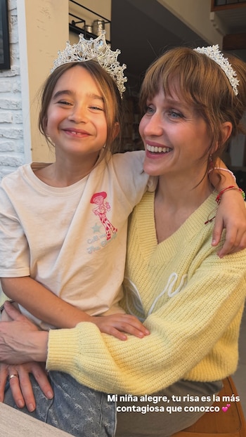 Brenda Gandini abraza a su hija Alfonsina; ambas llevan tiaras plateadas y sonríen a la cámara
