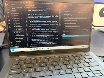 Una laptop negra con la pantalla encendida muestra código en un editor de texto y una aplicación con instrucciones sobre un agente de IA; se ve parte del teclado