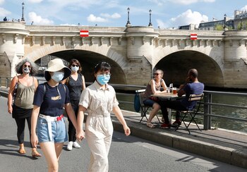 Peatones con máscaras protectoras caminan