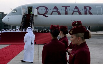 FILE PHOTO: Qatar Airways cabin crew stand in front of an Airbus A350-1000 at Hamad International Airport in Doha, Qatar, February 21, 2018. REUTERS/Naseem Zeitoon/File Photo