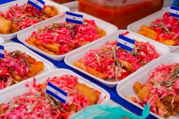 Platos de yuca frita con curtido y pescaditos fueron repartidos a los asistentes para festejar el mes patrio (Foto cortesía Alcaldía de San Salvador Centro)