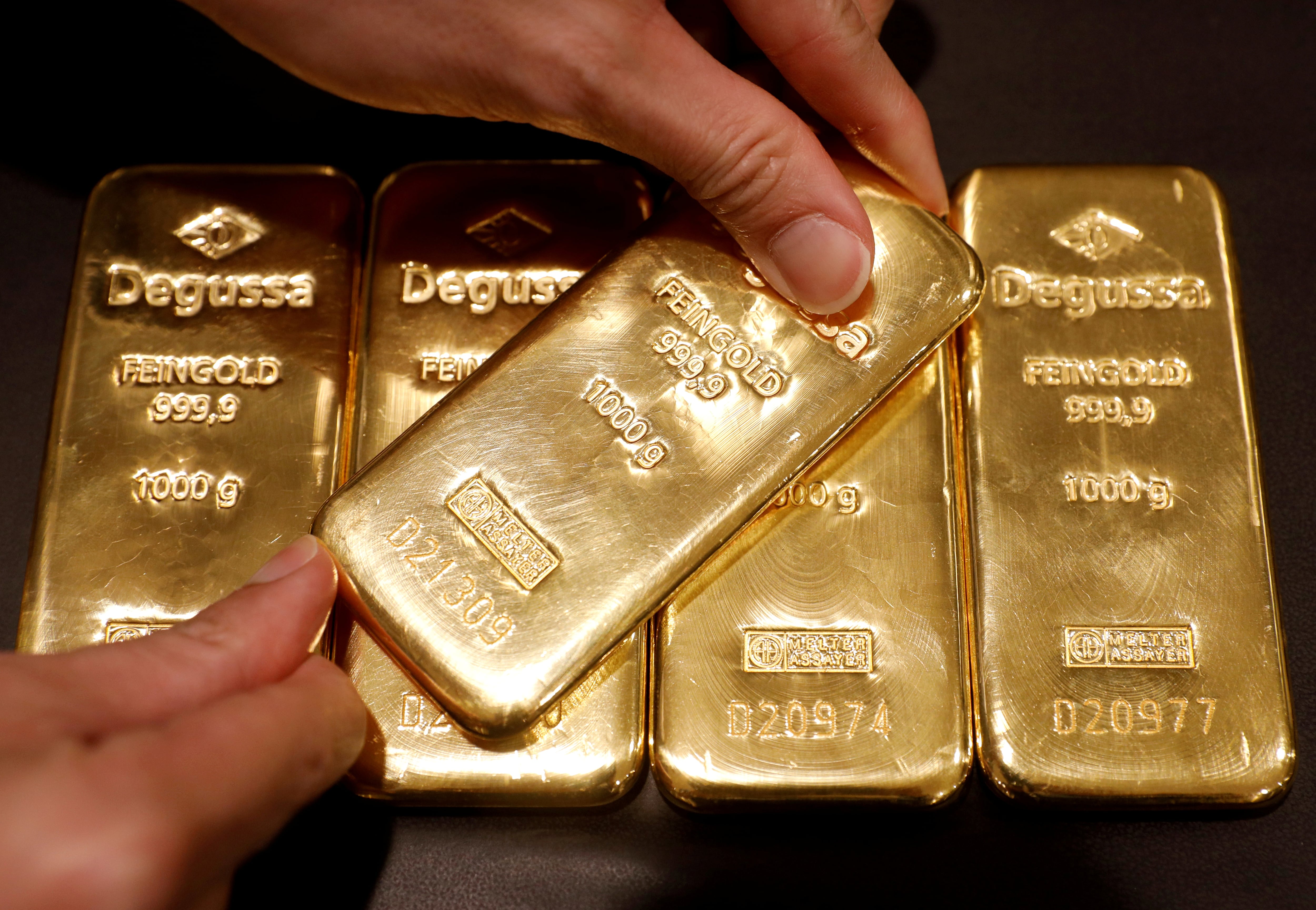 FILE PHOTO: An employee shows gold bullions at Degussa shop in Singapore June 16, 2017. Picture taken June 16, 2017. REUTERS/Edgar Su/File Photo