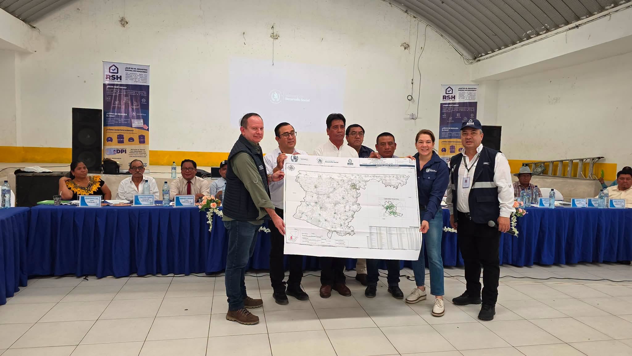 Un grupo de funcionarios presenta un mapa detallado del Registro Social de Hogares durante un evento sobre desarrollo social. (Mides Guatemala)