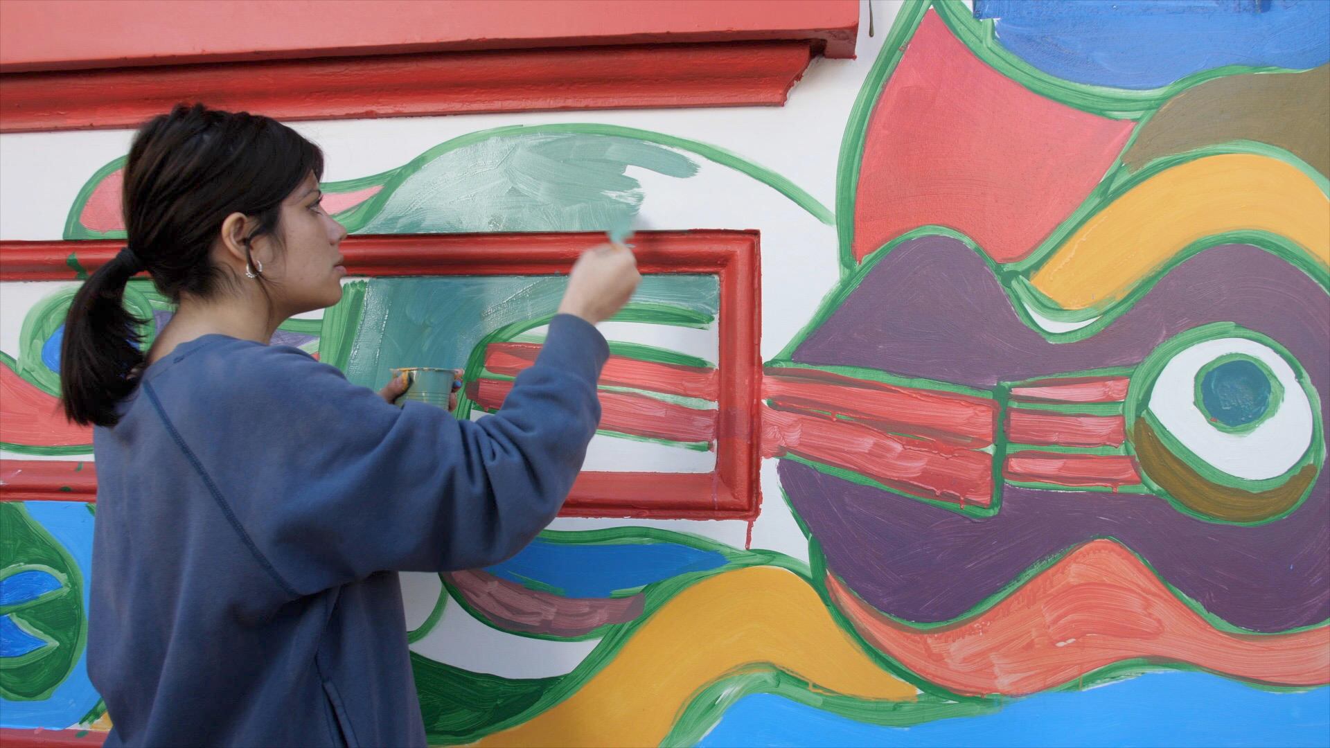 Una integrante de la Brigada Ramona Parra (BRP), realizando un mural en Santiago (Chile)