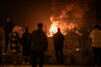 Varias personas observan cómo arde