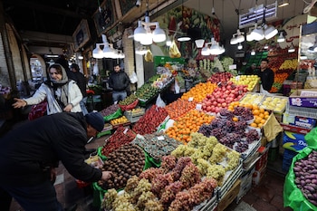 Personas compran frutas en el