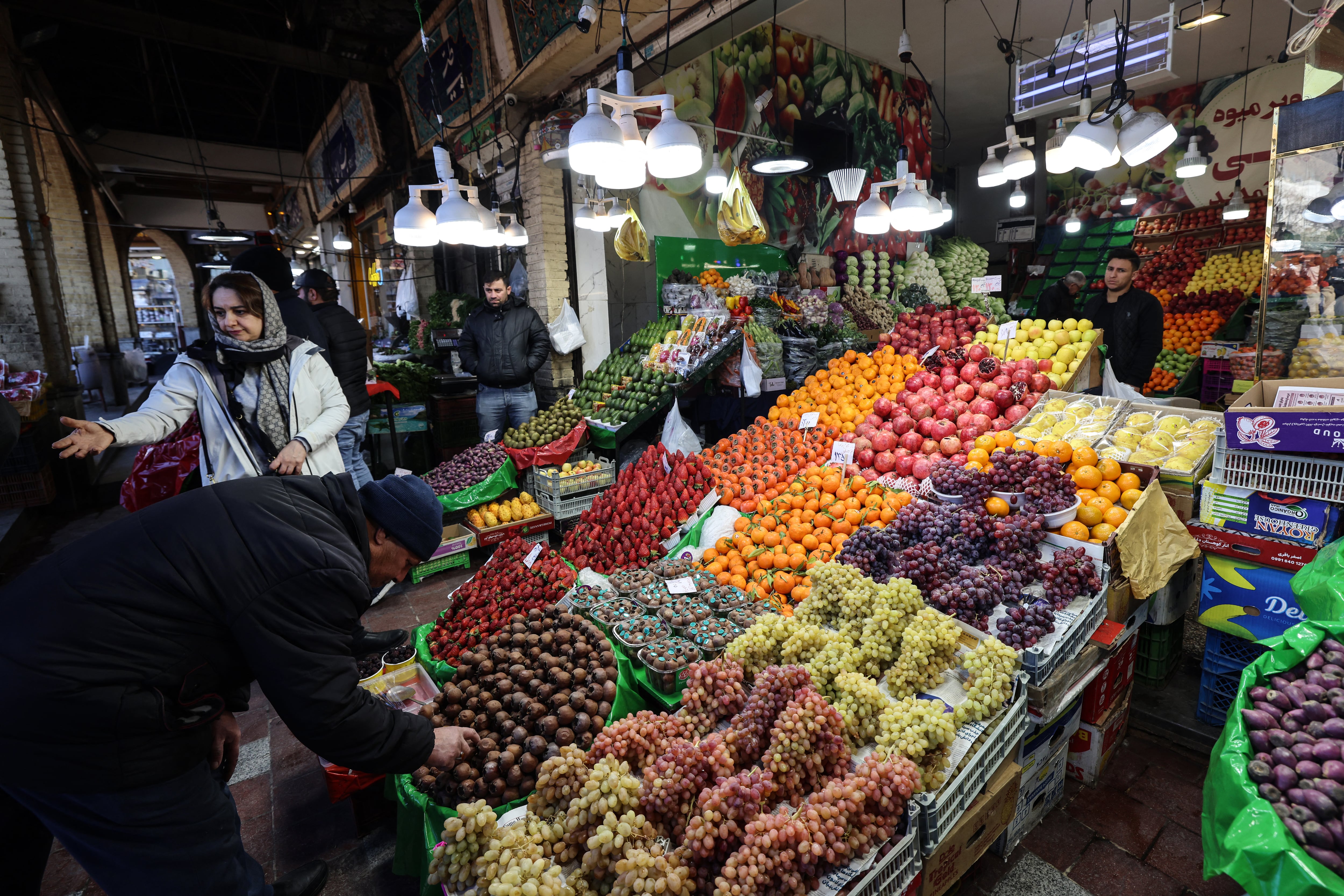 Personas compran frutas en el Bazar de Tajrish en Teherán, el 29 de diciembre de 2025. La rápida depreciación del rial está elevando los precios de alimentos y tensionando los presupuestos familiares (Foto de ATTA KENARE / AFP)