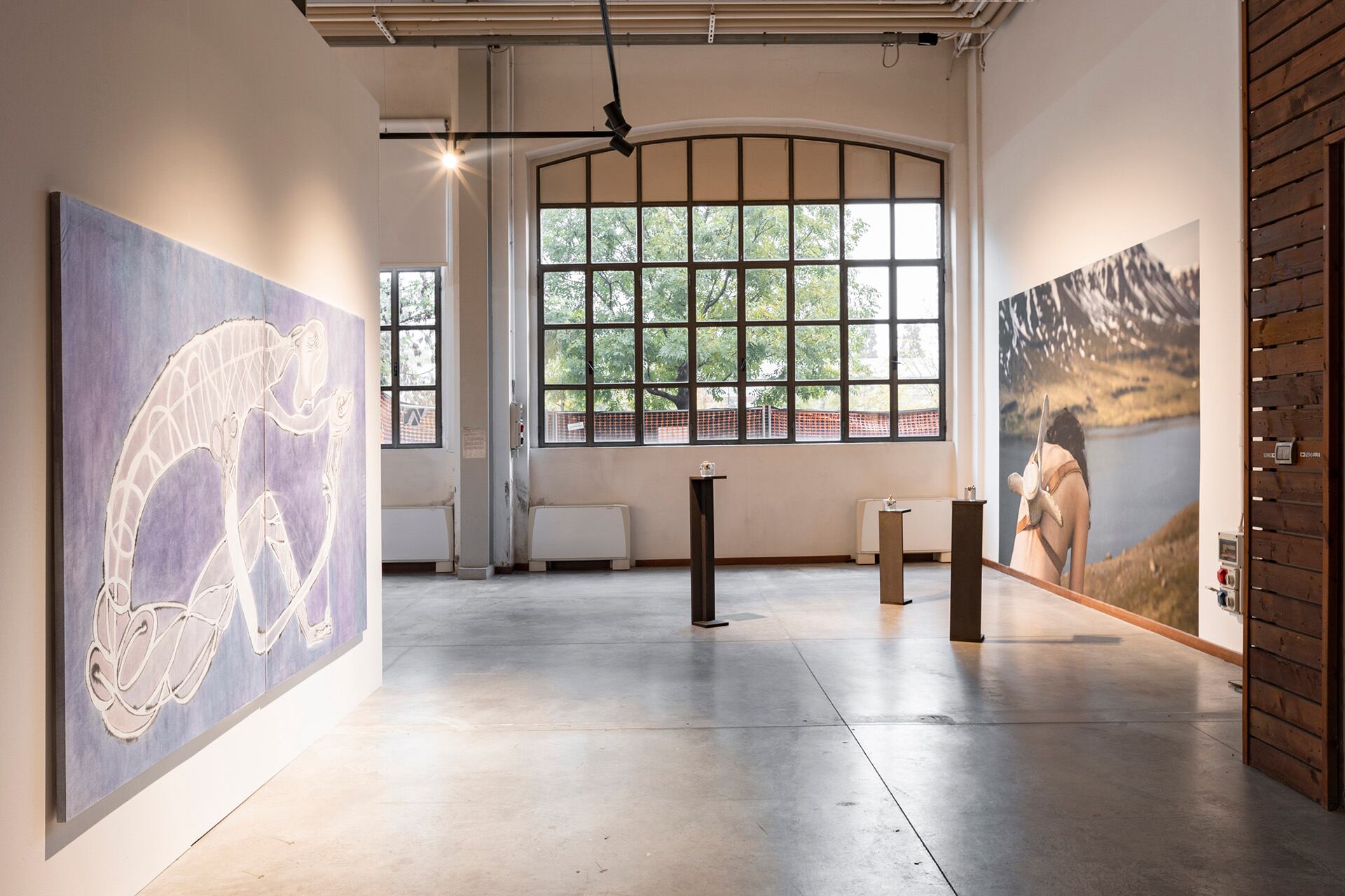 A la izquierda, la obra de la argentina Carla Grunauer, donde una figura humana se curva sobre sí misma, como un anfibio