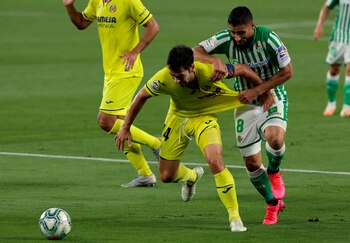 El delantero francés del Real Betis Nabil Fekir (d), lucha con Manuel Trigueros, del Villarreal, durante el partido de la jornada 33 de LaLiga que se jugó en el estadio Benito Villamarín, en Sevilla. EFE/Julio Muñoz