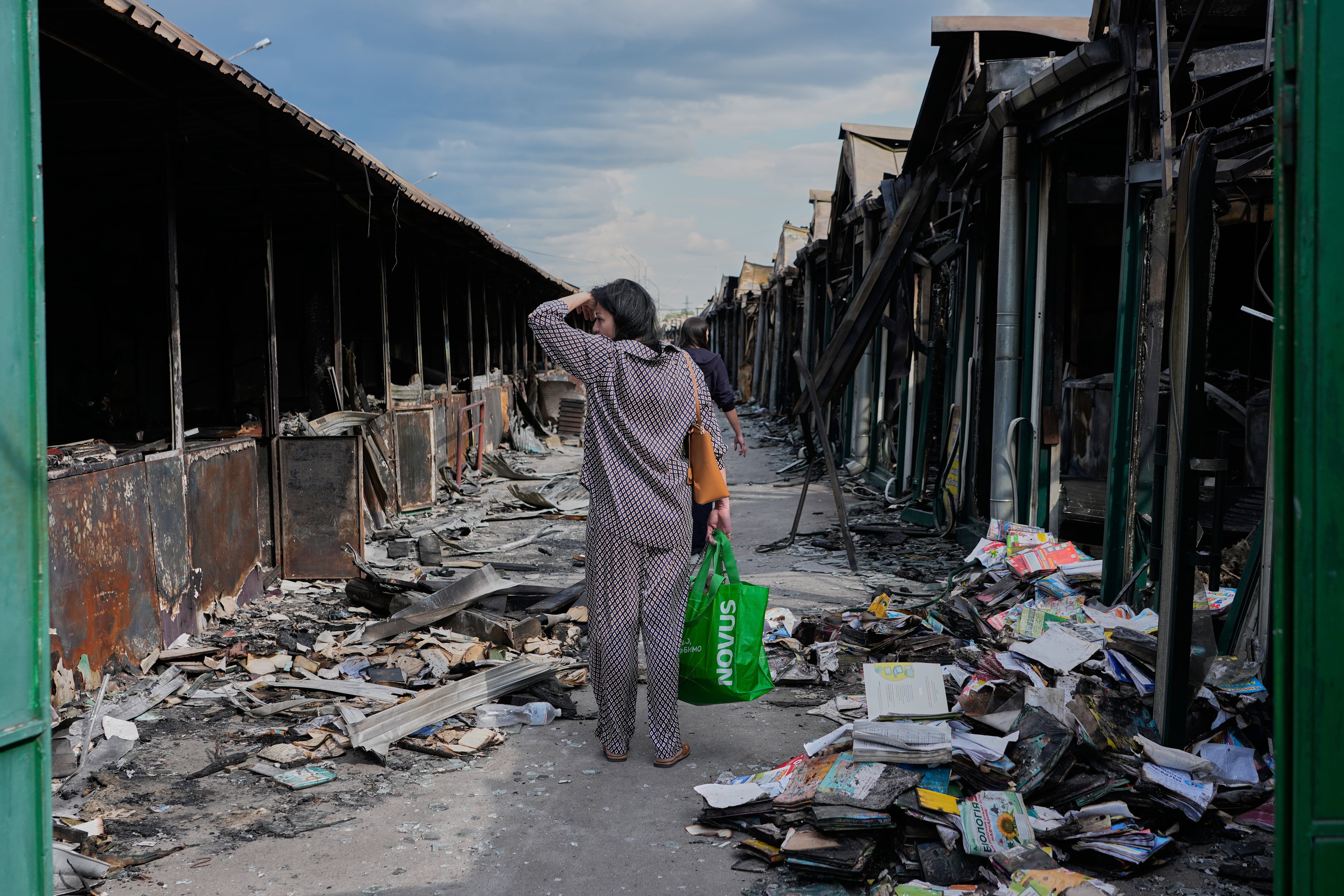 Una mujer reacciona ante libros calcinados tras un incendio en el mayor mercado de libros del país, provocado por un ataque con misiles rusos en Kiev, Ucrania, el 19 de agosto de 2026. (Foto AP/Efrem Lukatsky, archivo)