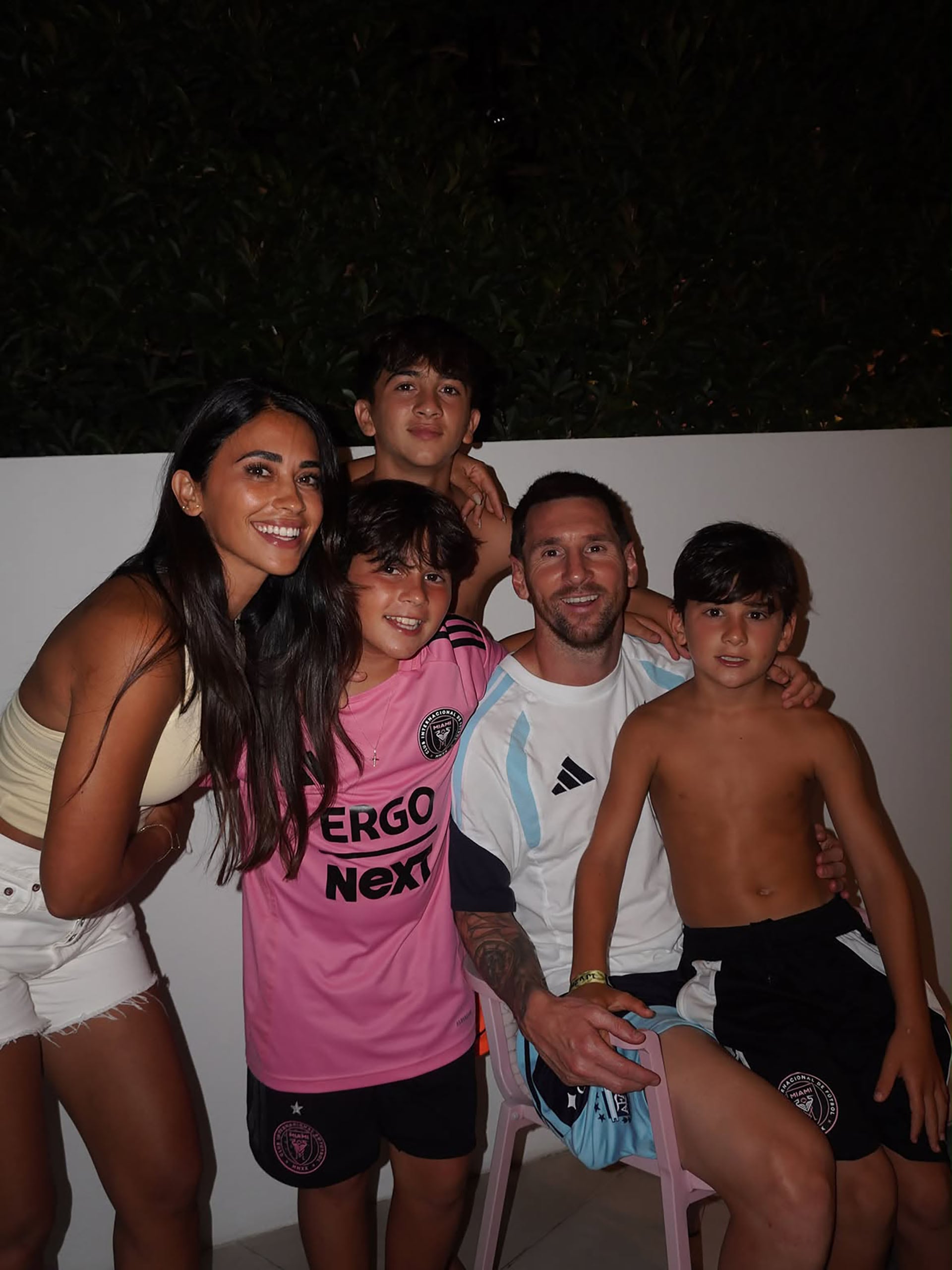 Antonela Roccuzzo y Lionel Messi sonríen junto a sus tres hijos en una fotografía familiar de noche al aire libre