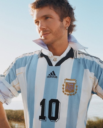 Franco Masini combina la camiseta albiceleste con camisa blanca y jeans de corte recto para un estilo híbrido