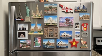 Imanes de monumentos de diversas ciudades y fotografías instantáneas están adheridos a la puerta de un refrigerador de acero.
