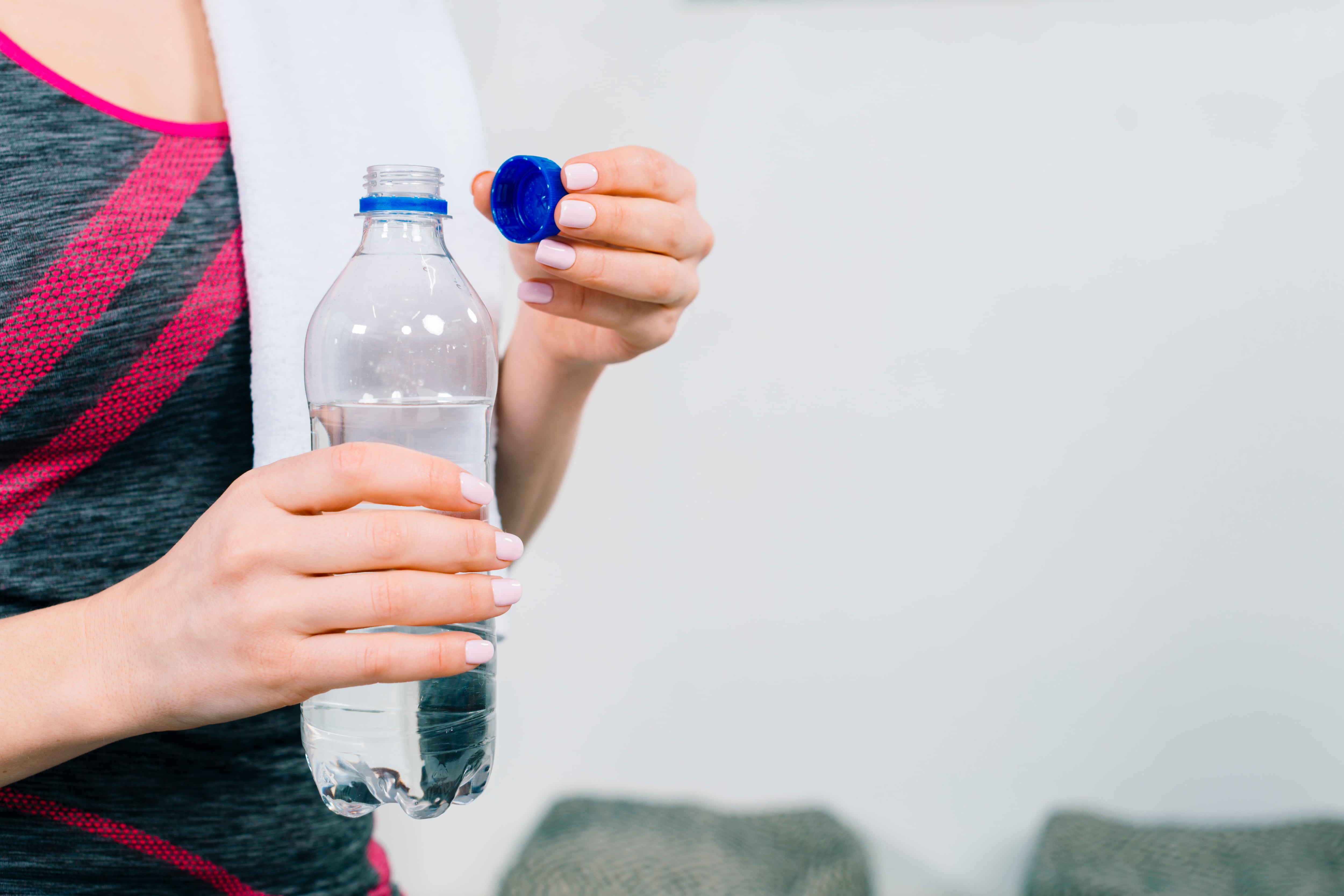 Mujer con una botella de agua. (Freepik)