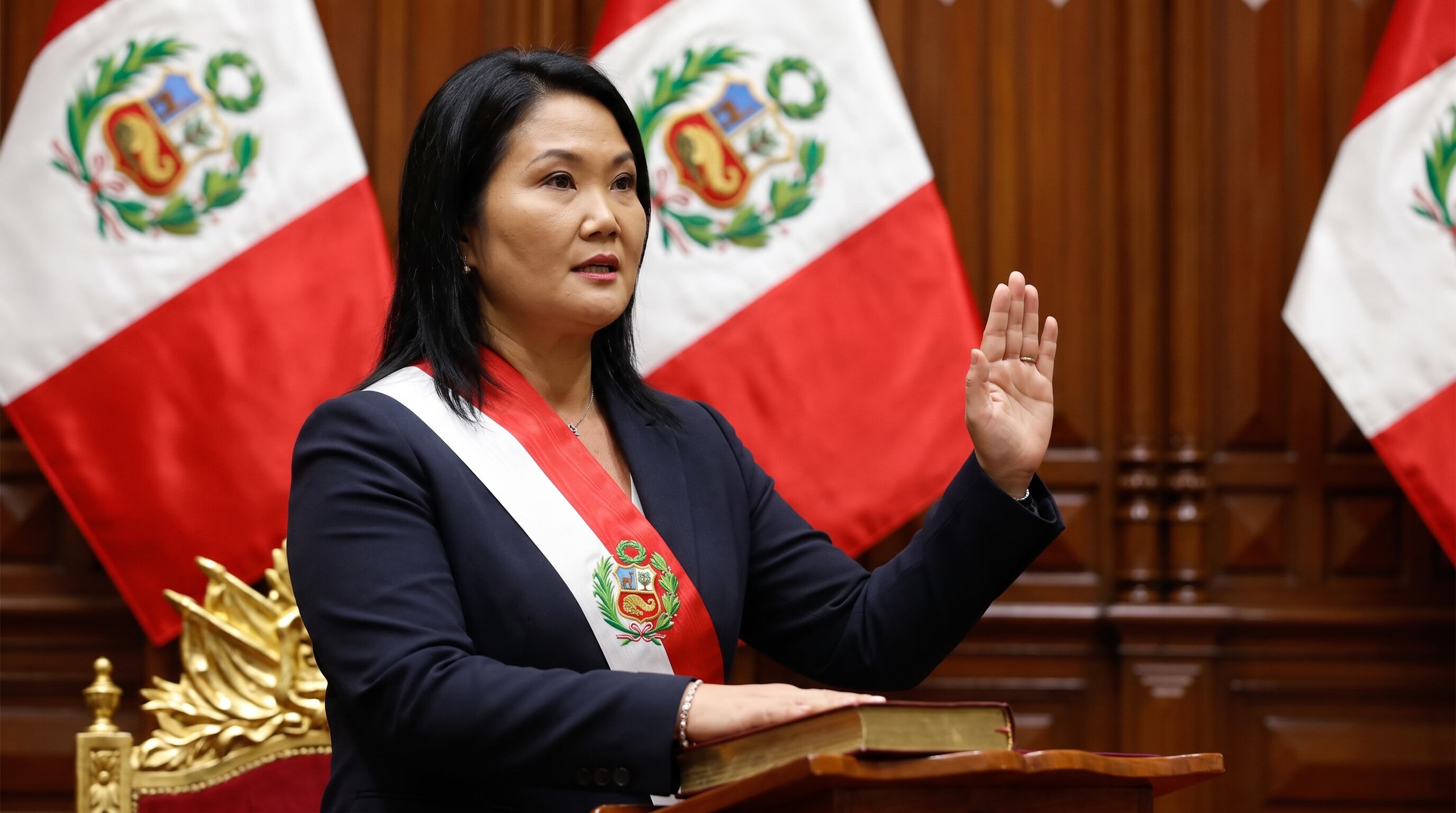 Keiko Fujimori realiza la juramentación presidencial en el Congreso del Perú, de pie frente a un podio con banderas nacionales de fondo. (Imagen Ilustrativa Infobae)