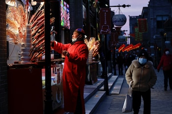 Un comerciante vendiendo Tanghulu antes de las celebraciones del Año Nuevo Lunar tras un brote de Covid-19 en Beijing, China, 8 de febrero, 2021. (REUTERS/Thomas Peter)