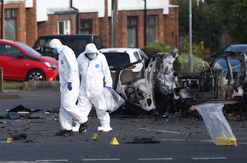 Investigadores forenses inspeccionan el lugar donde estalló un auto ante la comisaría de Dunmurry , en el sur de Belfast, el domingo 26 de abril de 2026. (AP Foto/Peter Morrison)