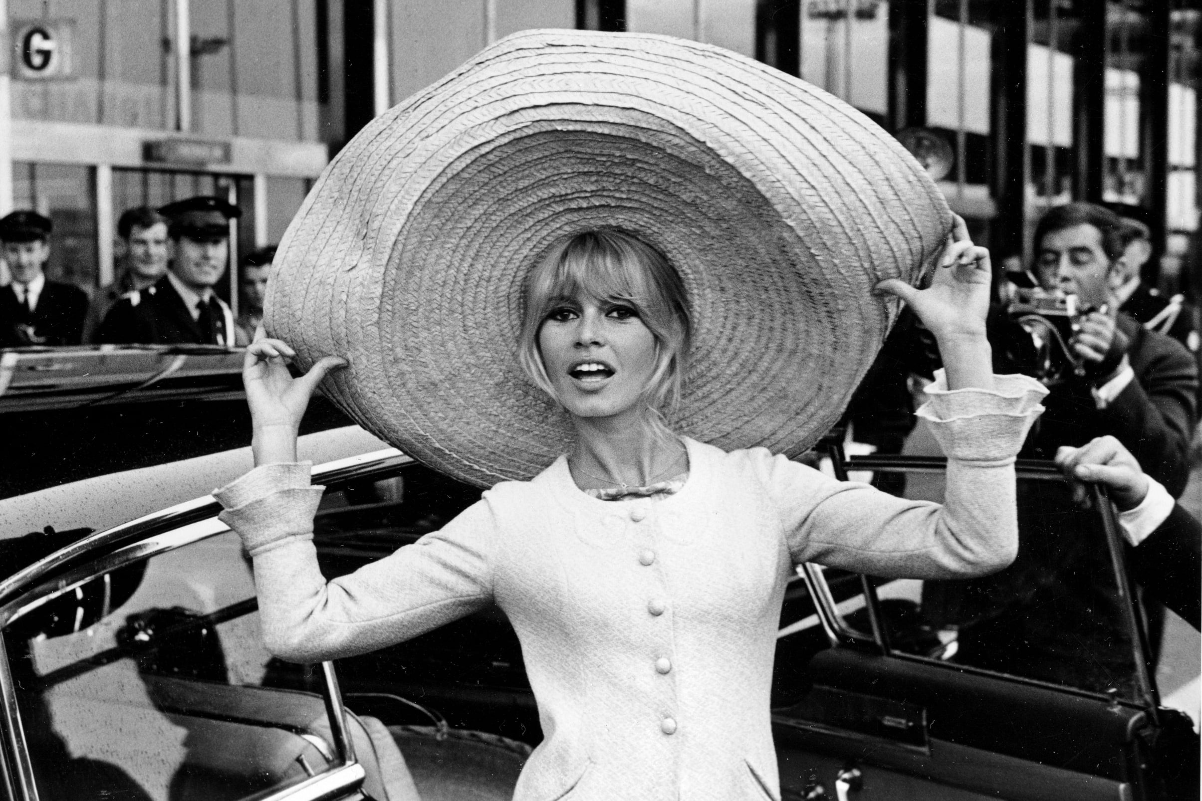 La actriz francesa Brigitte Bardot posa con un enorme sombrero que trajo de México, a su llegada al aeropuerto de Orly, el 27 de mayo de 1965, en París, Francia. (AP Foto/Archivo)