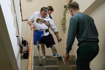 Anastasia ayuda a su esposo Serhiy Ponomarenko, un militar ucraniano a quien le amputaron dos extremidades después de luchar en el frente, mientras hace sus ejercicios matutinos en el centro de rehabilitación de Halychyna en Lviv, Ucrania, el 11 de noviembre de 2024. (Foto AP/Mykola Tys)