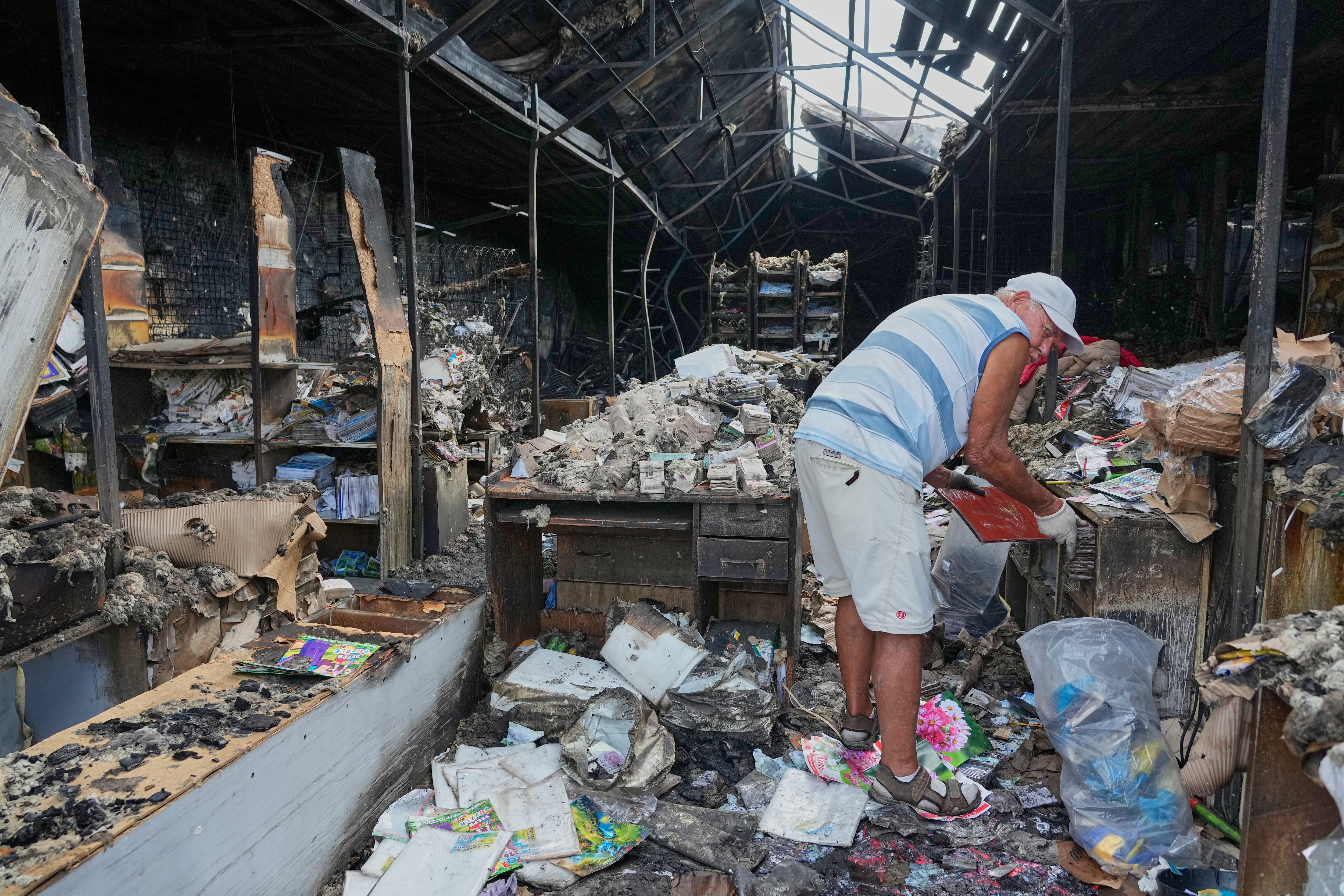 Un hombre revisa libros quemados tras un incendio en el mercado de libros más grande del país, provocado por un reciente ataque con misiles rusos en Kiev, Ucrania, el 19 de agosto de 2026. (Foto AP/Efrem Lukatsky, archivo)