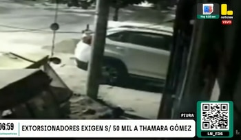Captura de video de baja resolución muestra una calle con un vehículo utilitario deportivo blanco estacionado, un poste y escombros en el suelo, con gráficos de noticias