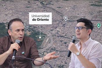 Dos hombres hablan con micrófonos frente a un mapa aéreo detallado de una ciudad, con la etiqueta 'Universidad de Oriente' y otros puntos de interés visibles.