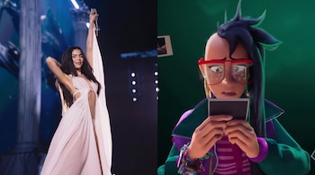 Una mujer con vestido blanco canta en un escenario iluminado junto a un personaje animado con gafas rojas que sostiene una foto.
