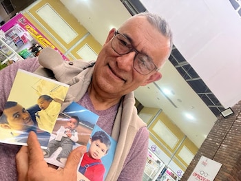 Idelmo con fotografías de Carlos cuando era pequeño. (Cedida)