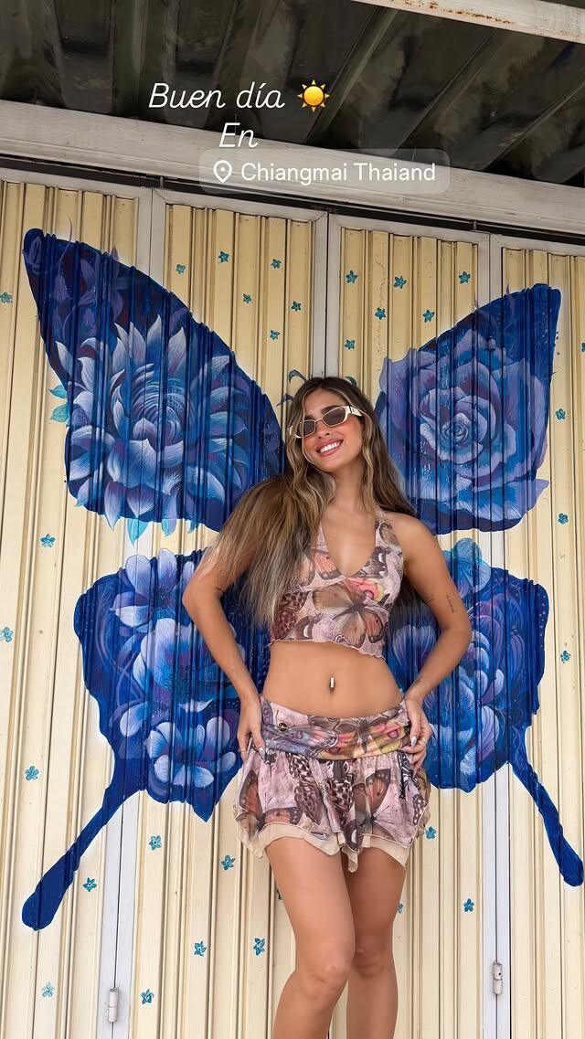 En Chiang Mai, la influencer posó frente a una puerta decorada con alas y flores en tonos vibrantes
