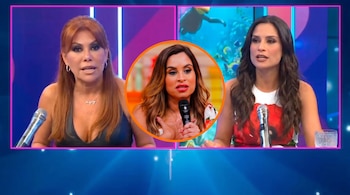 Dos mujeres en un set de televisión con micrófonos y una tercera mujer en un recuadro circular central. Fondo azul con luces y escena acuática animada.
