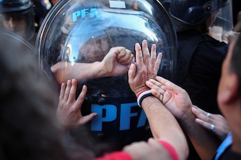 Un agente de la PFA contiene el avance de manifestantes. REUTERS/Agustin Marcarian