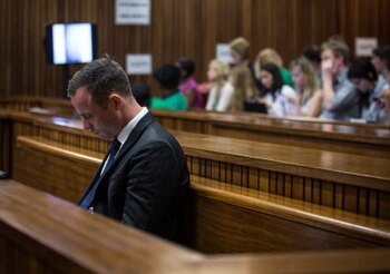 South African Paralympic athlete Oscar Pistorius sits in the dock on day eleven of his trial for the murder of his girlfriend Reeva Steenkamp, at the North Gauteng High Court in Pretoria, on March 17, 2014. Pistorius is on trial for murdering his girlfriend Reeva Steenkamp at his suburban Pretoria home on Valentine's Day last year. He says he mistook her for an intruder. AFP PHOTO/POOL/ DANIEL BORN (Photo credit should read DANIEL BORN/AFP/Getty Images)