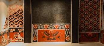 Murales prehispánicos de Teotihuacan con patrones geométricos, cabezas de animales estilizadas y grandes aves míticas en tonos rojos, negros y blancos