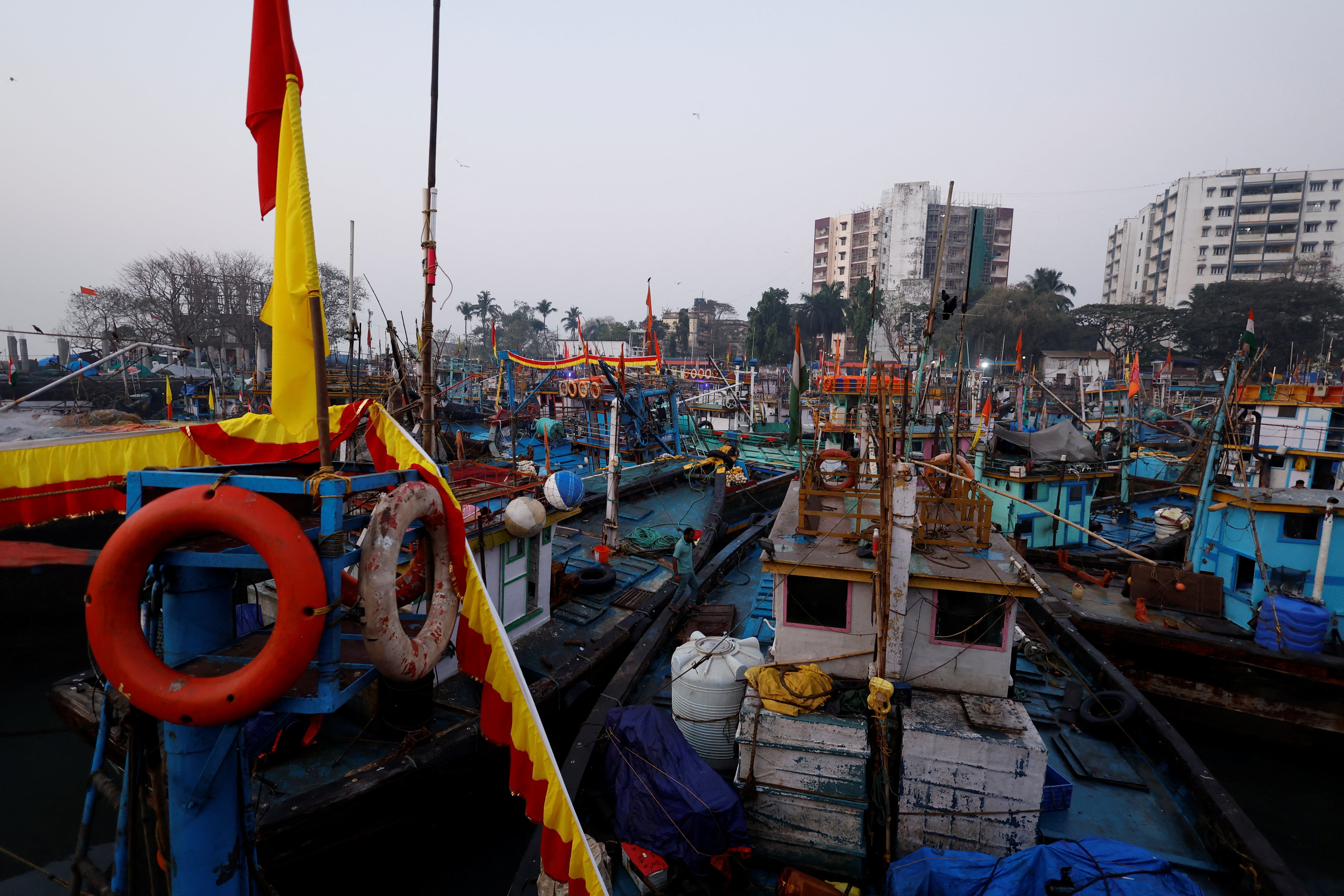 Un hombre cruza un barco pesquero en el muelle Sassoon, Bombay, India (REUTERS/Francis Mascarenhas)