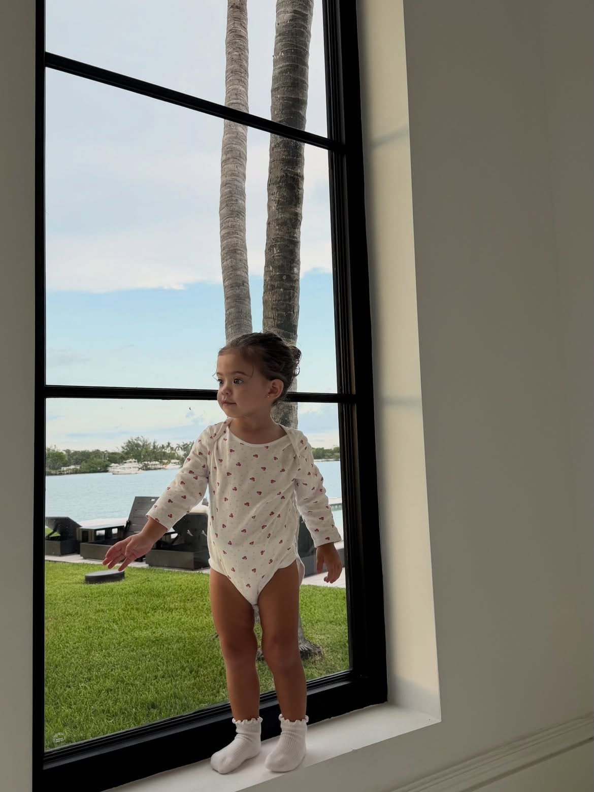 Con un body blanco con corazones, Olivia posó en uno de los grandes ventanales de la propiedad