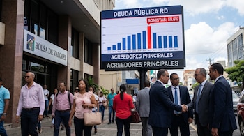 Cartel digital exhibe gráfico de deuda pública RD con bonistas como 58.6% de acreedores. Edificio de Bolsa de Valores y personas en la calle.
