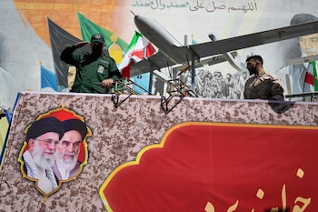 Un miembro de la Guardia Revolucionaria de Irán saluda a bordo de una carroza para exhibir drones durante el "Janfada" ("Sacrificio por Irán"), un desfile de estilo militar organizado por el Estado, en Teherán, Irán, el 18 de septiembre de 2026 (AP Foto/Vahid Salemi)