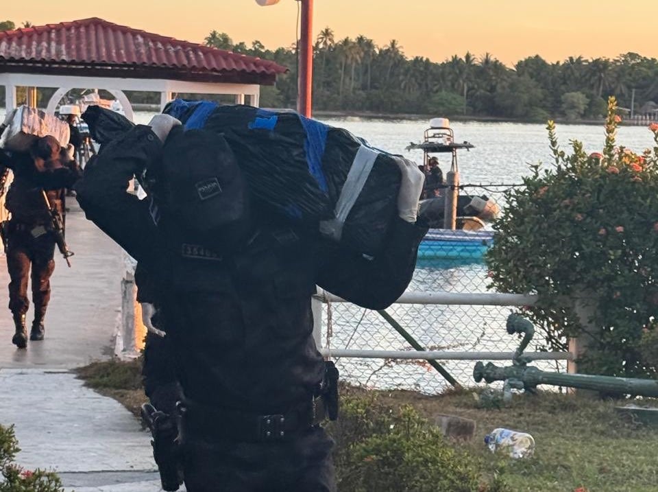 Agentes de la PNC trasladan los paquetes de droga luego de haber interceptado la embarcación esta madrugada. /(Redes ministro de Justicia y Seguridad, Gustavo Villatoro)
