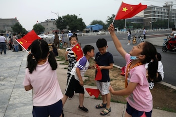 Niños ondean banderas nacionales chinas