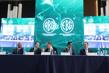 Cinco hombres en trajes de negocios sentados detrás de una mesa azul en un panel de discusión, con pantallas gigantes mostrando logos de ABG y EBG al fondo