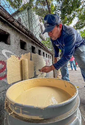 El operativo de restauración emplea rodillos y brochas para reparar superficies públicas y privadas afectadas por pintas y daños materiales. (Cortesía: Alcaldía de San Salvador)
