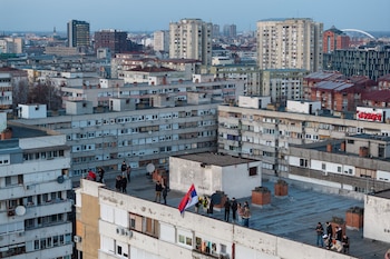 Un grupo de personas protesta desde la terraza de un edificio en Novi Sad (REUTERS/Marko Djurica)