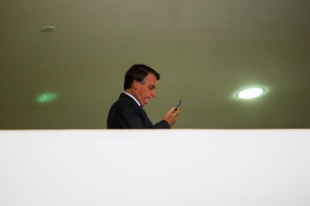 Bolsonaro mirando su teléfono celular