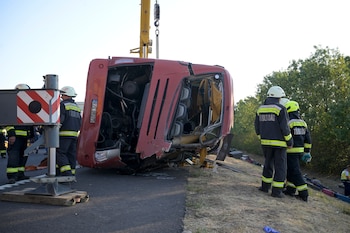 Trabajadores de emergencias asisten al lugar después de que un autobús de pasajeros se saliera de la carretera y volcara en una cuneta junto a una autopista entre Mezokeresztes y Mezonagymihaly en Hungría, el domingo 16 de agosto de 2026. (Zoltan Mathe/MTI via AP)