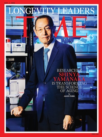 Portada de la revista TIME con un hombre en traje y lentes. Fondo de laboratorio con estantes y material científico. Títulos: LONGEVITY LEADERS, Shinya Yamanaka