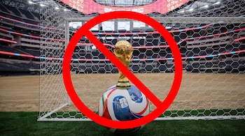 Un trofeo dorado de la Copa del Mundo sobre un balón de fútbol blanco y azul, dentro de un arco. Una señal de prohibido roja cubre el centro de la imagen.