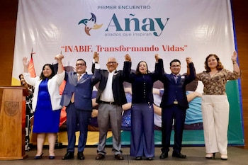 Seis personas en un escenario, con brazos levantados y manos unidas, posan frente a un banner del 'Primer Encuentro Añay' e 'INABIF, Transformando Vidas'