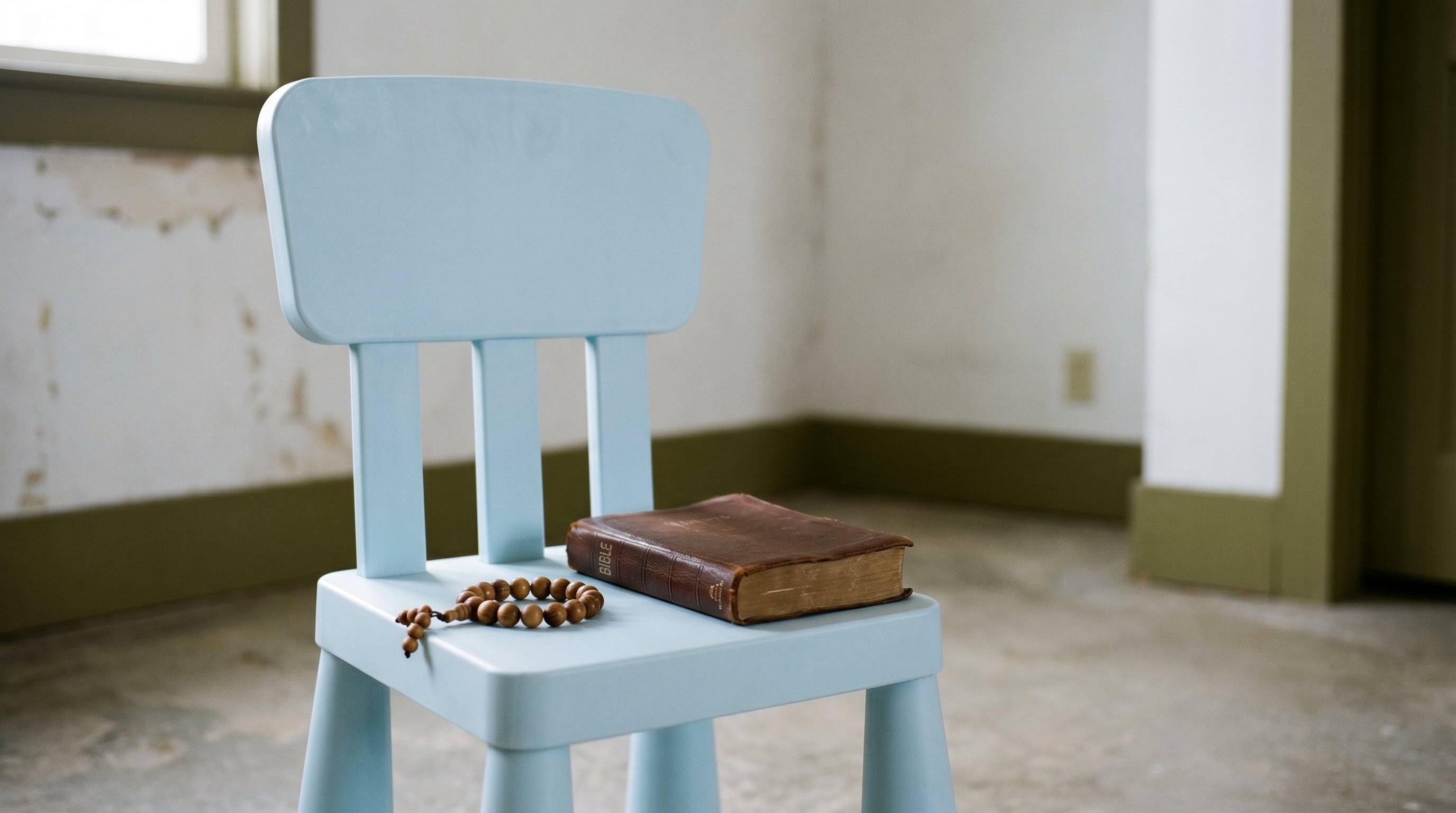 En una habitación sencilla, una silla infantil azul claro luce vacía con una Biblia cerrada y una pulsera de cuentas de madera sobre su asiento, bajo una luz natural fría. (Imagen Ilustrativa Infobae)