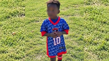 Un niño con el rostro difuminado viste una camiseta azul y roja con el número diez sobre una superficie de hierba