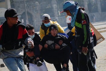 Un manifestante es transportado por